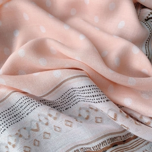 Détail d'une écharpe en coton rose avec pois blancs et motifs géométriques bohémiens
