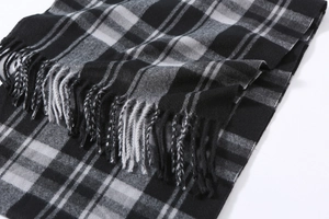 Close-up of black and white plaid scarf featuring soft texture and fringe details