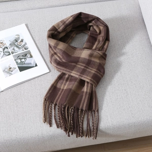 Close-up of classic brown and khaki plaid scarf texture with fine fringe details