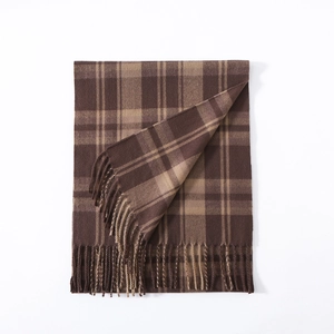 Detail of classic brown plaid scarf with hand-twisted tassels and thick wool-like texture