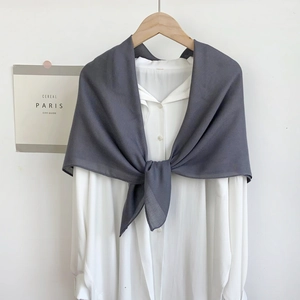 Detail of dark grey lightweight cotton linen shawl styled over a minimalist white shirt