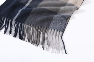 Detailed view of the plaid tassel scarf featuring navy blue and grey twill weave texture