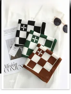 Detail of checkered velvet scarves with herringbone pattern and clover motif