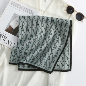 Close-up of floral square scarf with B-letter print and SIYA brand tag on white shirt