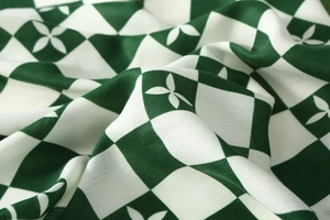 Close-up of green and white checkerboard velvet scarf with floral petal patterns