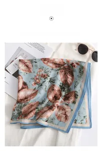 Close-up of printed silk-feel square scarf with hand-painted leaf patterns on white clothing