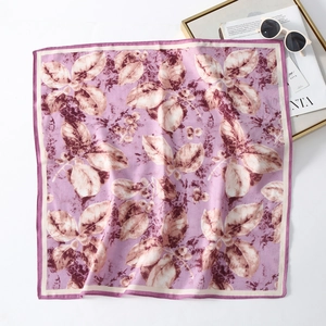Detailed view of square silk scarf with purple leaf patterns and neat edge stitching