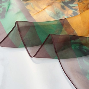 Macro shot of semi-transparent scarf fabric with abstract geometric patterns and rolled hem