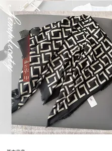 Close-up detail of soft black and white geometric pattern scarf with fringe edges