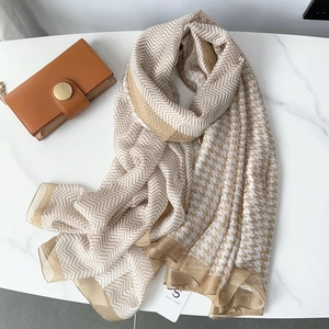 Detailed macro view showing the houndstooth and chevron pattern on khaki silk scarf