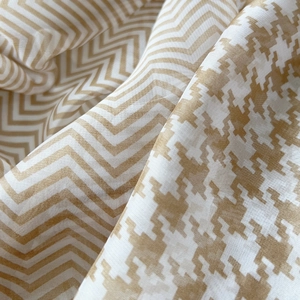 Detailed macro view showing the texture of houndstooth and herringbone patterns on soft shawl