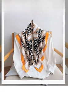 Détail du tissu en polyester aspect soie avec motif léopard et motifs orange vif