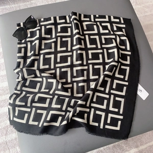 Detail of black and white geometric pattern scarf with delicate frayed edges and brand tag