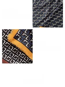 Dettaglio macro di sciarpa geometrica con blocchi blu navy, arancio e bordo sfrangiato