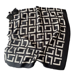 Fashionable black and white geometric pattern scarf paired with stylish black sunglasses