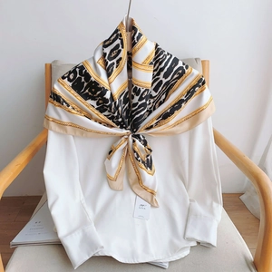 Foulard en soie avec imprimé léopard et chaînes dorées sur une chemise blanche