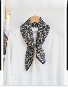Close-up of black and white pattern cotton neck scarf tied on a white shirt collar