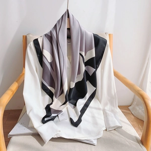 Detail of elegant silk scarf with black and white abstract geometric patterns on a white shirt