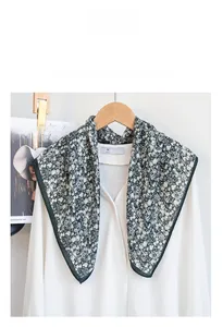 Detail of floral cotton square scarf styled on a classic white collared shirt