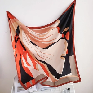 Detail of elegant large silk scarf featuring modern abstract patterns and orange accents