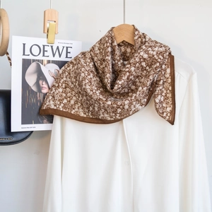 Detail of vintage floral cotton scarf in brown and beige styled with a white shirt