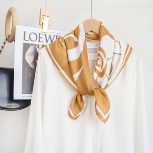 Dettaglio ravvicinato di un foulard in seta floreale annodato su un colletto bianco