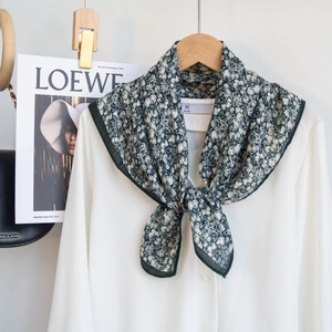 Detail view of lightweight floral silk scarf paired with a white shirt for elegant styling