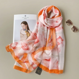 Detailed view of lightweight floral scarf with vibrant orange edges and soft textures