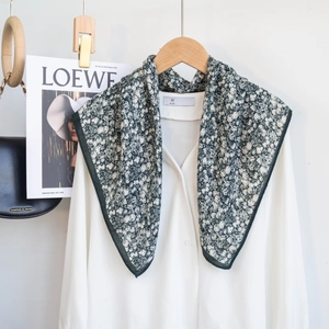 Detailed view of dark green floral cotton scarf paired with a classic white shirt outfit