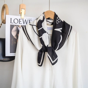 Vista dettagliata di un foulard in seta bianco e nero con stampa floreale e trama fine