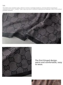 Detailed close-up of the fringed edge and jacquard pattern on a black and white scarf