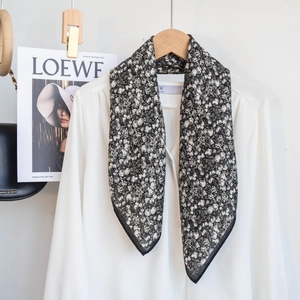 Floral black and white cotton neck scarf styled on a white blouse with a minimalist look