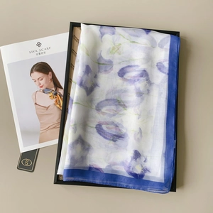 Detail of elegant floral long scarf with purple blooms and dark blue border trim