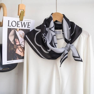Dettaglio di un foulard in seta a fiori bianco e nero abbinato a una camicia bianca