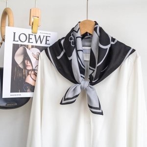 Dettaglio di un elegante foulard in seta nero e grigio con motivi floreali astratti