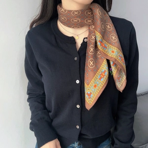 Close-up of vintage brown cotton linen scarf with badge patterns and silk texture