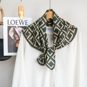 Detailed view of dark green geometric printed silk scarf tied on a white shirt collar