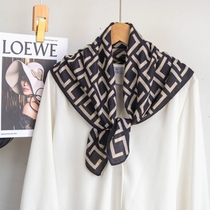 Detail of black and white geometric pattern scarf worn with a white shirt