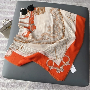 Orange and beige square silk scarf with classic horse harness patterns and frayed edges