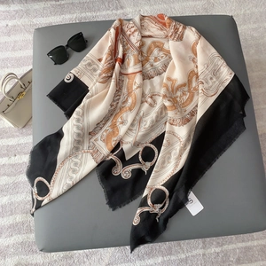 Detail view of retro chain print scarf with orange accents and fine fringe borders