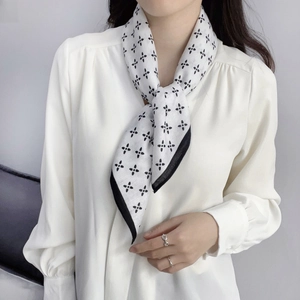 Eleganter schwarz-weißer Seidenschal mit Kleeblattmuster auf weißer Chiffonbluse