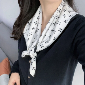 Detailansicht eines eleganten schwarz-weißen quadratischen Tuchs auf einem Cardigan