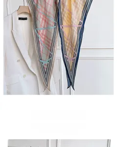 Détail d'un foulard en soie losange avec motifs à carreaux roses et bleus et bords contrastés