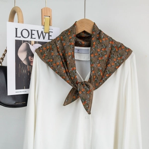 Brown floral silk scarf tied on a white shirt with elegant retro flower patterns