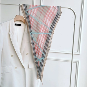 Détail d'un foulard en soie imprimé fin avec motif de chaîne sur un blazer blanc