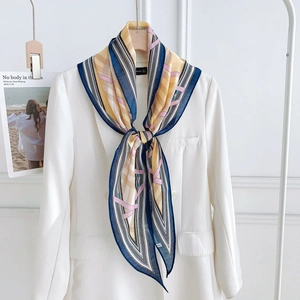 Détail d'un foulard en soie à motif géométrique sur un blazer blanc avec imprimé chaîne