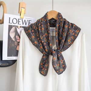 Close-up of floral neck scarf on white shirt with magazine and chain bag props