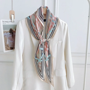 Écharpe en soie à motif géométrique et chaîne portée sur un blazer blanc élégant
