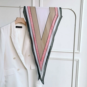 Detail of multi-color silk scarf with French lettering on white blazer lapel
