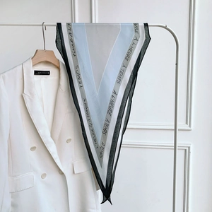 Modern V-pattern geometric silk scarf with French typography on a sleek hanger
